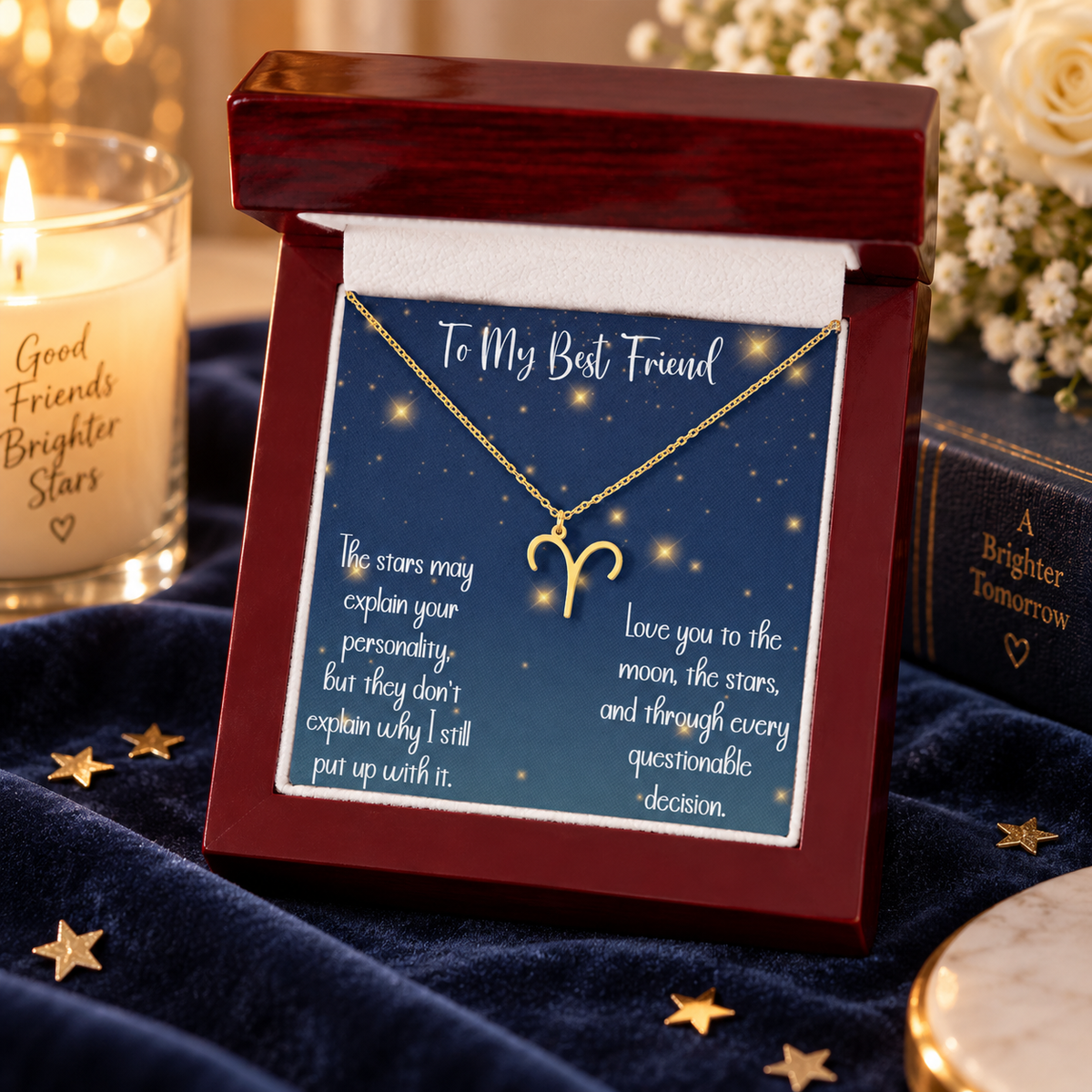 A gold Aries zodiac symbol necklace displayed on a starry blue card inside an open dark red wooden gift box. The card reads 'To My Best Friend' and includes a heartfelt message about stars and decisions.